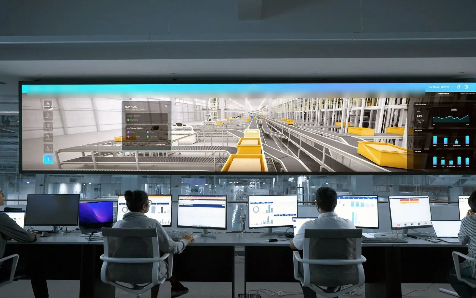 A modern plant operations center with operators at a bank of consoles facing a large video wall of dashboards.