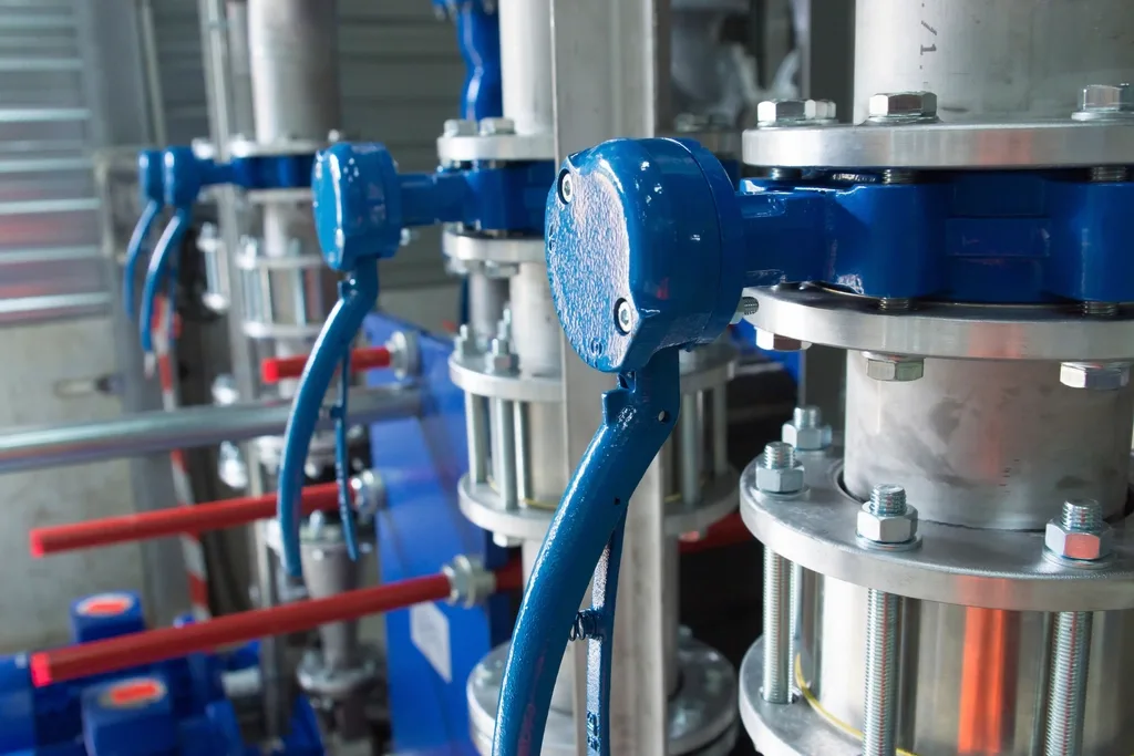 A manifold of blue-painted valves with instrument tubing on a process skid.