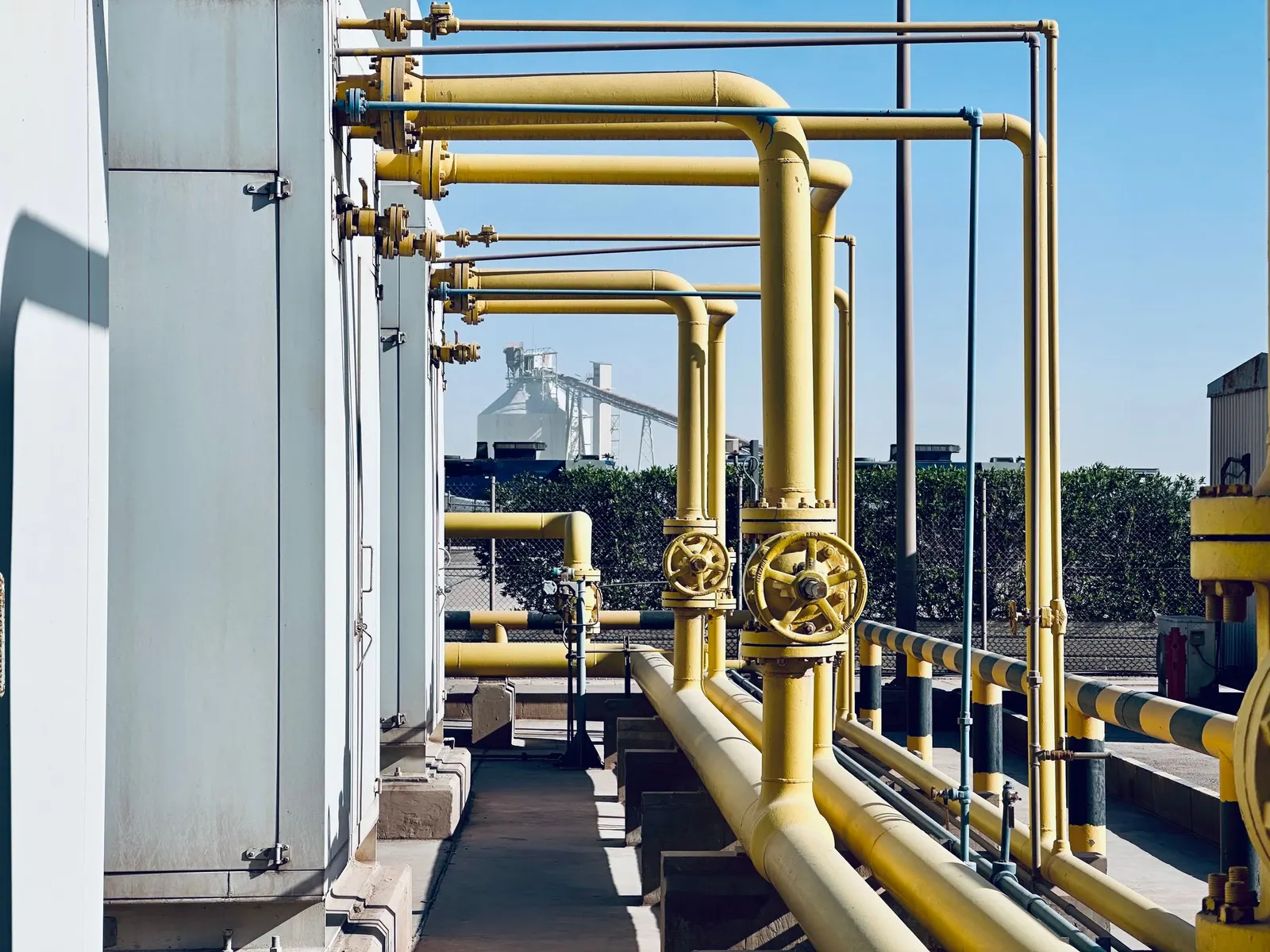 Process piping with control valves and handwheels at an industrial plant.